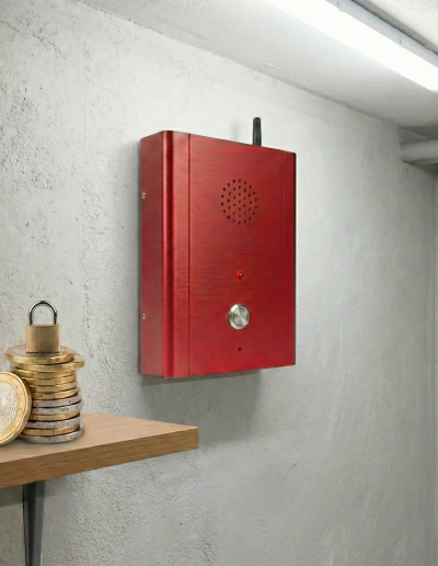 Boîtier d'appel d'urgence GSM mural rouge avec antenne pour sécurité ERP. Présence d'un cadenas sur des pièces et d'une coche verte, symbolisant la conformité économique et technique